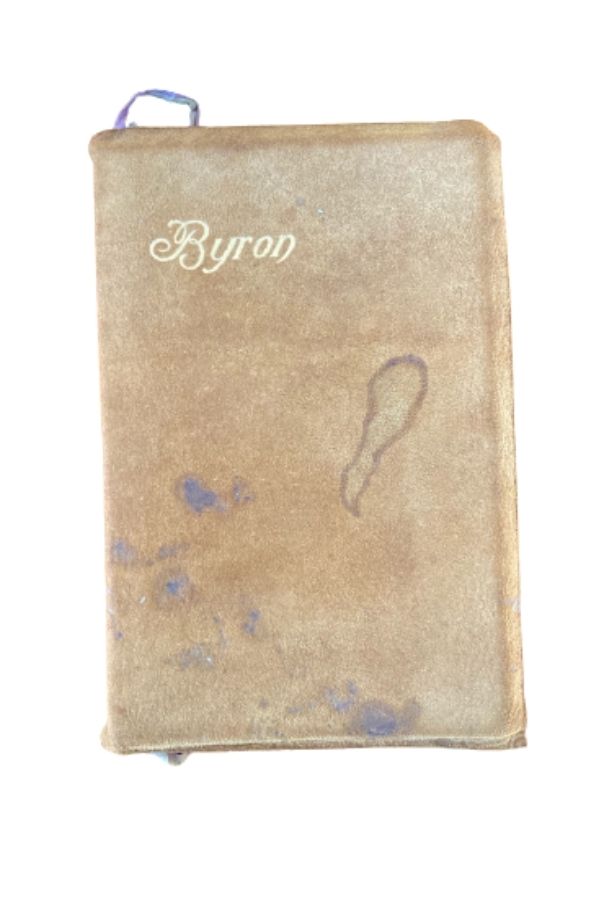 An older leatherbound brown book with stains and "Byron" embossed at the top in gold."