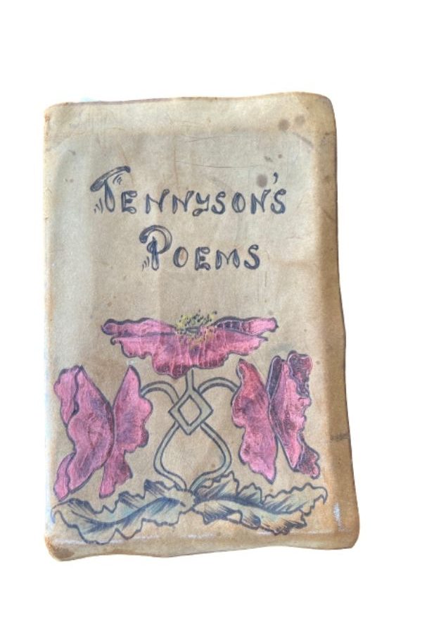 Brown book with red flowers drawn on the cover, titled "Tennyson's Poem"